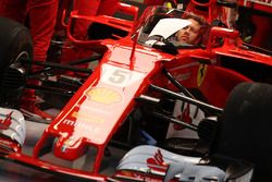 Sebastian Vettel, Ferrari, sits in the cockpit of his car, which is fitted with a new protective win