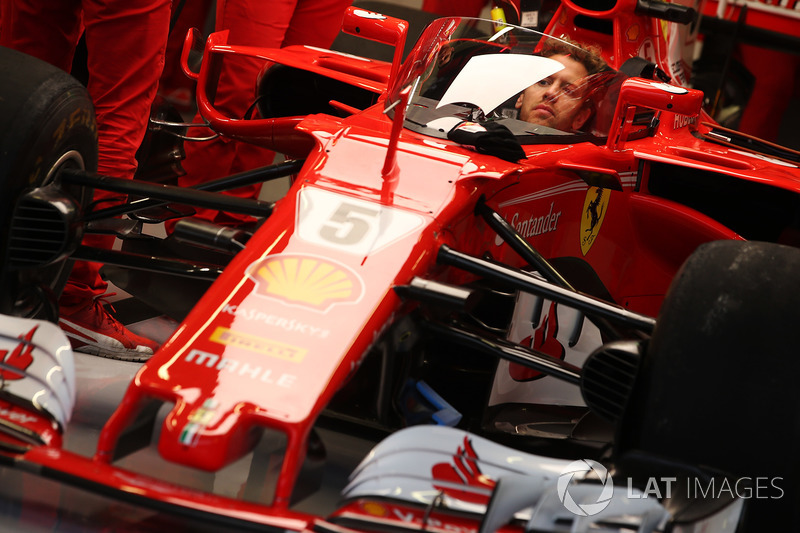 Sebastian Vettel, Ferrari, sits in the cockpit of his car, which is fitted with a new protective win