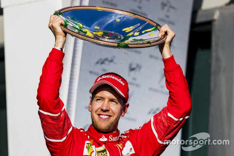 Sebastian Vettel, Ferrari, 1st Position, holds his trophy aloft