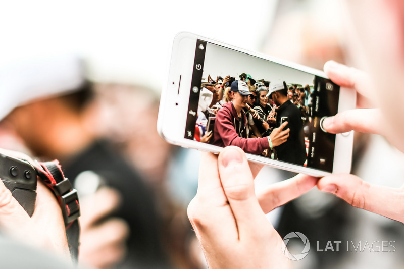 On a phone shows Lewis Hamilton, Mercedes AMG F1 sign autographs for the fans