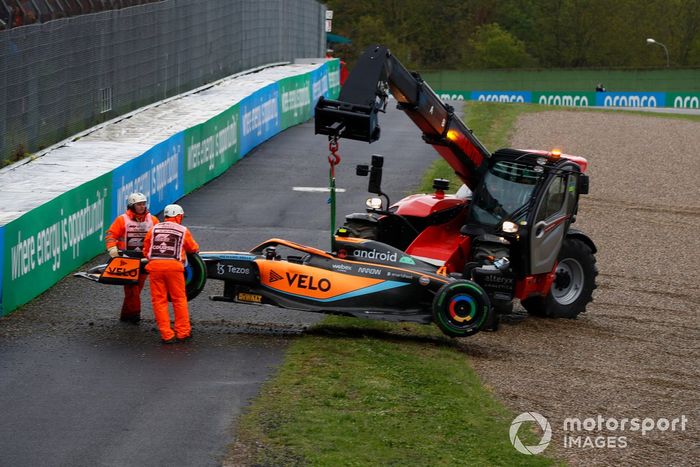 Oficiales de pista retiran el coche de Lando Norris, McLaren MCL36, de la barrera