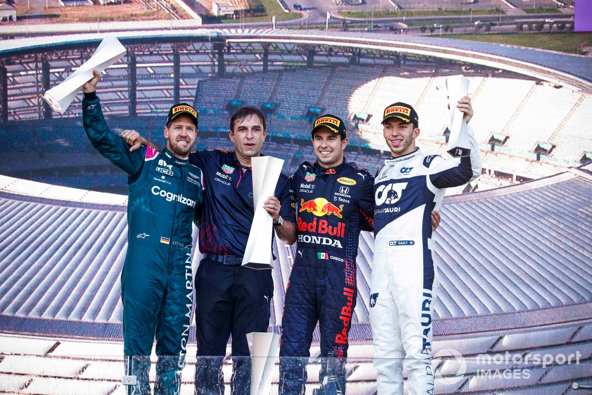 Sebastian Vettel, Aston Martin, 2nd position, the Red Bull trophy delegate, Sergio Perez, Red Bull Racing, 1st position, and Pierre Gasly, AlphaTauri, 3rd position, on the podium