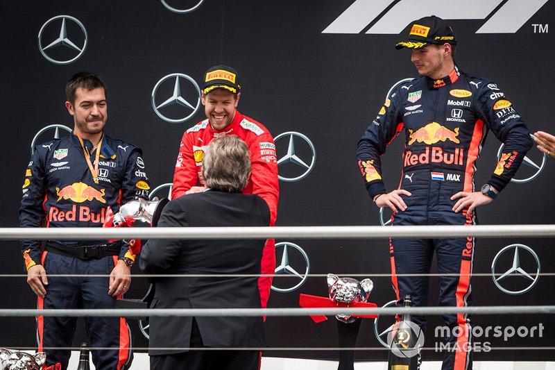 Sebastian Vettel, Ferrari, 2nd position, receives his trophy alongside Max Verstappen, Red Bull Racing, 1st position, on the podium