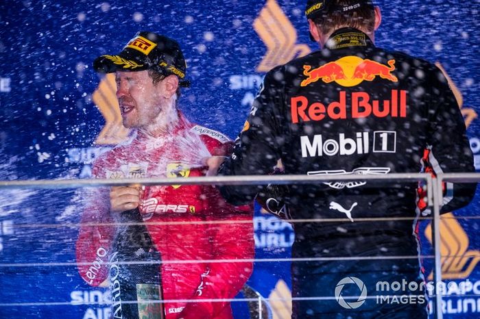 Sebastian Vettel, Ferrari, 1st position, and Max Verstappen, Red Bull Racing, 3rd position, spray Champagne on the podium