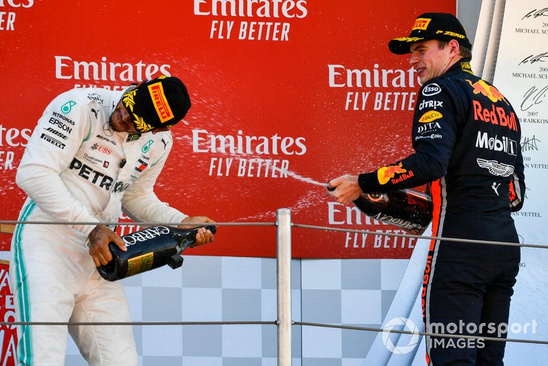 Lewis Hamilton, Mercedes AMG F1, primo posto, spruzza lo Champagne a Max Verstappen, Red Bull Racing, terzo posto, sul podio