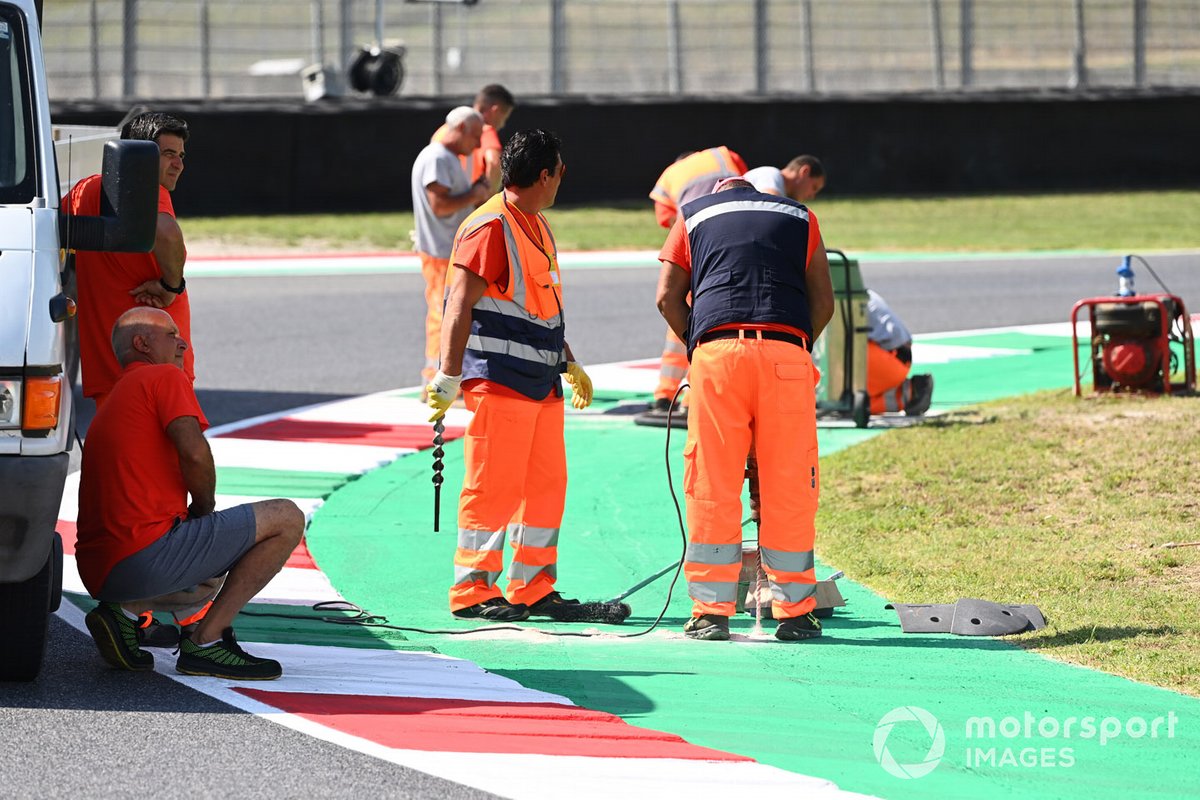 Operai riparano la pista e il cordolo