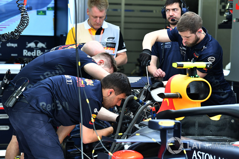 Red Bull Racing mechanics work on Red Bull Racing RB14 in the garage