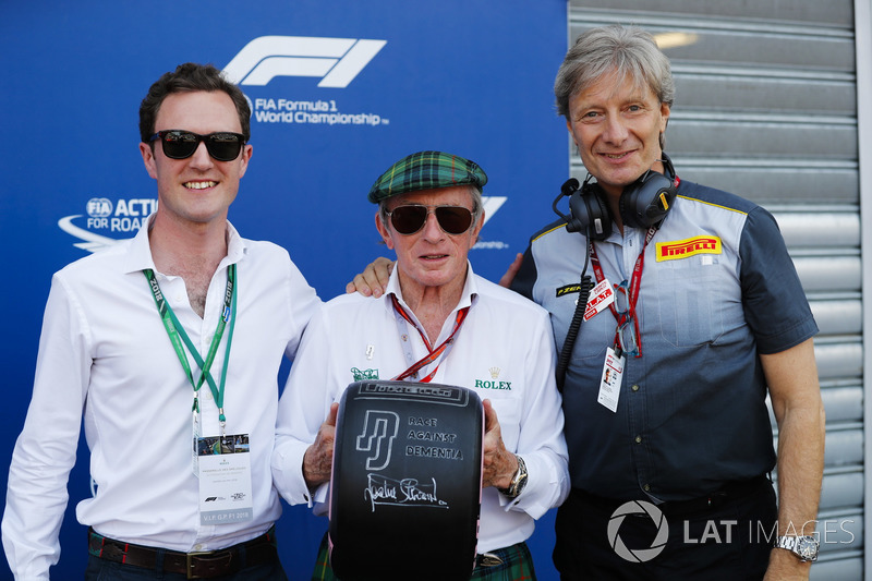 Sir Jackie Stewart con uno pneumatico con il messaggio "Race Against Dementia"