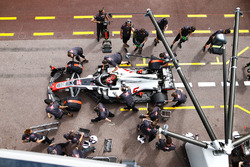 Kevin Magnussen, Haas F1 Team VF-18, is serviced by mechanics in the pit lane