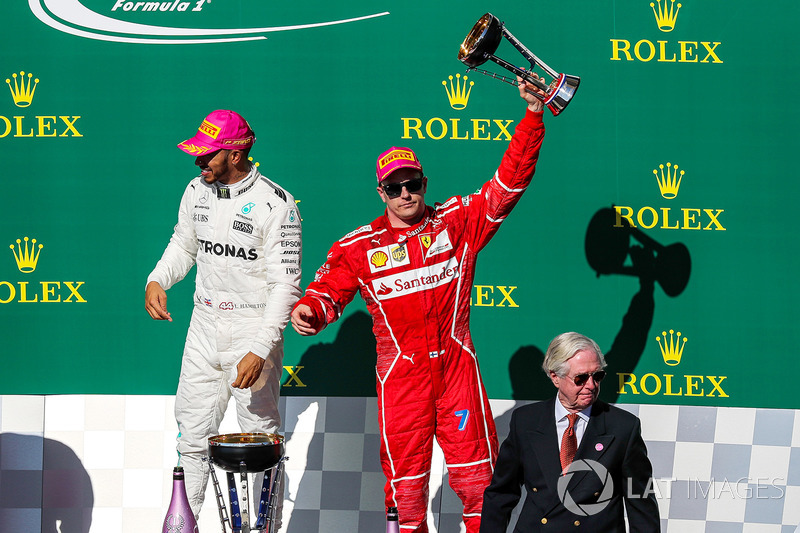 Third place Kimi Raikkonen, Ferrari celebrates on the podium with the trophy