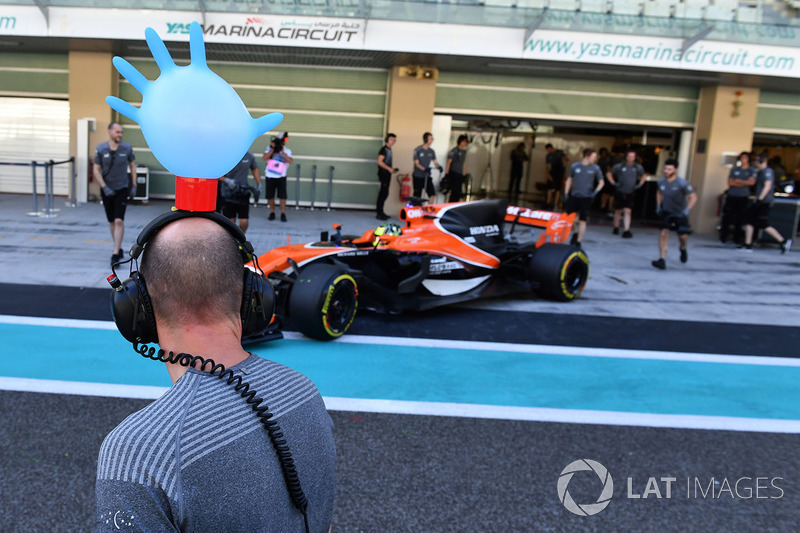 Lando Norris, McLaren MCL32 y un mecánico de McLaren con un guante sobre sus cascos