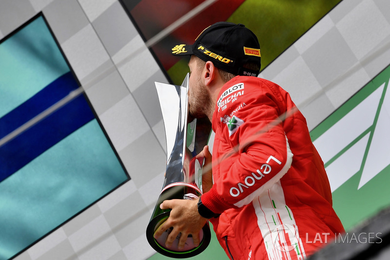 Race winner Sebastian Vettel, Ferrari celebrates and kisses the trophy on the podium