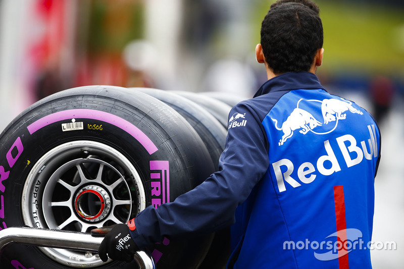 Un mécanicien de Toro Rosso pousse un chariot de pneus Pirelli dans le paddock