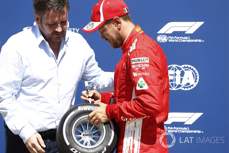 Sebastian Vettel, Ferrari, signs the Pirelli Pole Position Award as Paul Hembrey, Director, Pirelli Motorsport, looks on