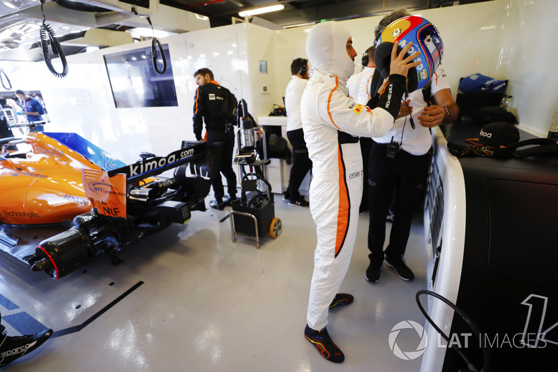 Fernando Alonso, McLaren, puts on his helmet in the team's garage
