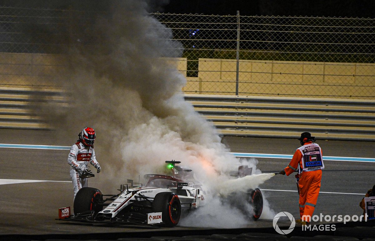A marshal extinguishes the flames on the car of Kimi Raikkonen, Alfa Romeo Racing C39