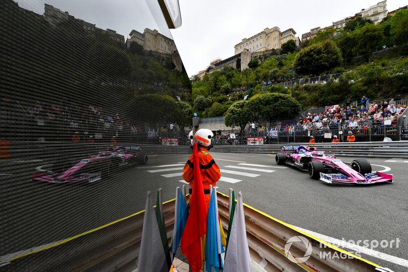 A marshal keeps an eye on the circuit as Lance Stroll, Racing Point RP19, passes