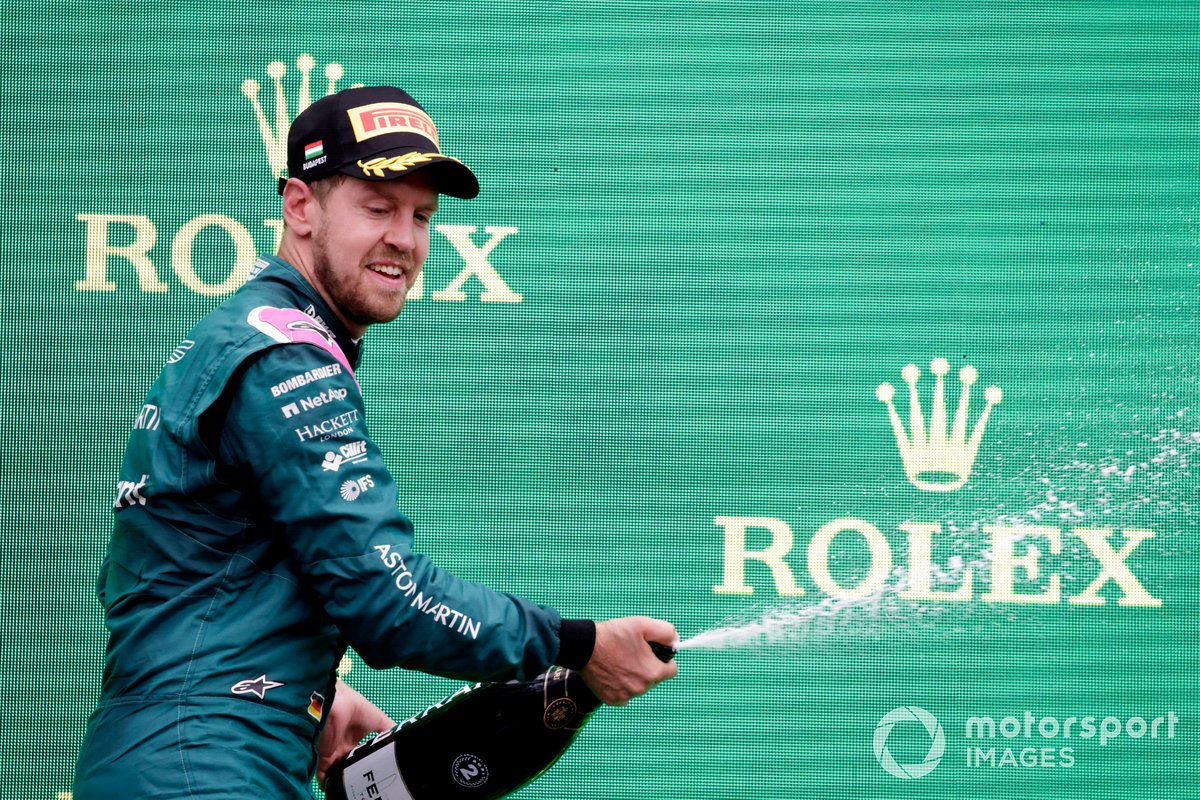 Sebastian Vettel, Aston Martin, secondo classificato, spruzza Champagne sul podio