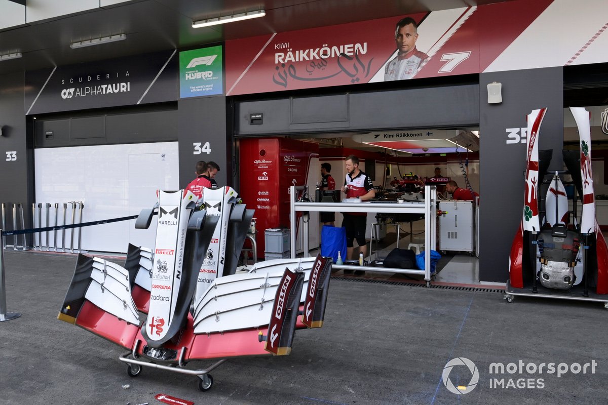 Des ailerons de rechange devant le stand Alfa Romeo