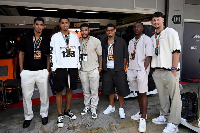 Jude Bellingham, Levi Colwill, Reece James, Morgan Gibbs-White, Eberechi Eze, James Trafford posent pour une photo à l'extérieur du garage McLaren. 
