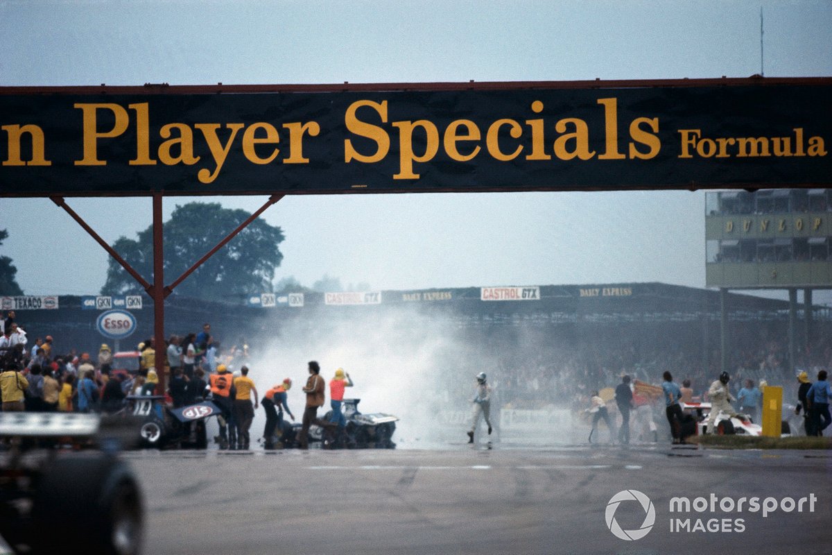 Clearing work after one lap and the mass crash following the start. Graham Hill exits his Shadow DN1 Ford on the right