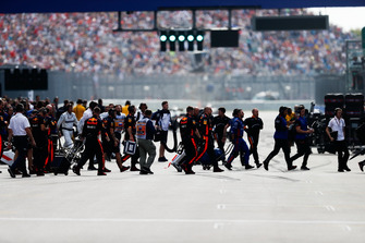 Engineers clear the grid after the cars head off for the formation lap