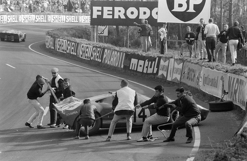 Marshals work to move the Ford GT40 of Peter Sutcliffe, Dieter Spoerry following an accident