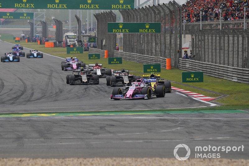Sergio Perez, Racing Point RP19, leads Nico Hulkenberg, Renault F1 Team R.S. 19, Romain Grosjean, Haas F1 Team VF-19, Kevin Magnussen, Haas F1 Team VF-19, Kimi Raikkonen, Alfa Romeo Racing C38, Lance Stroll, Racing Point RP19, and the remainder of the field on the opening lap