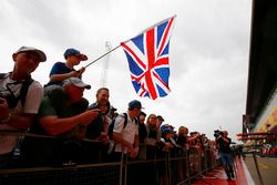 A young Lewis Hamilton, Mercedes AMG F1, supporter in a crowd waves a flag