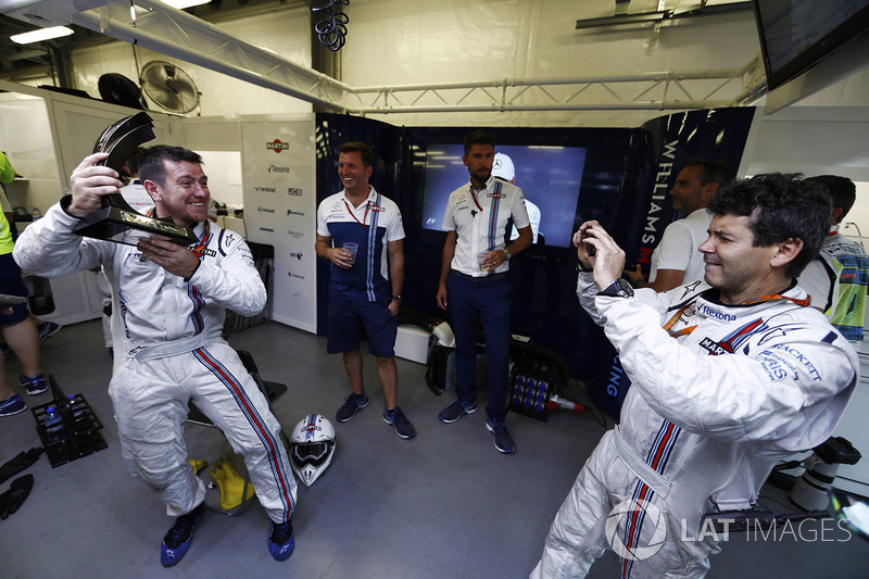 Un meccanico Williams scatta una foto ai colleghi con il terzo classificato Lance Stroll, Williams