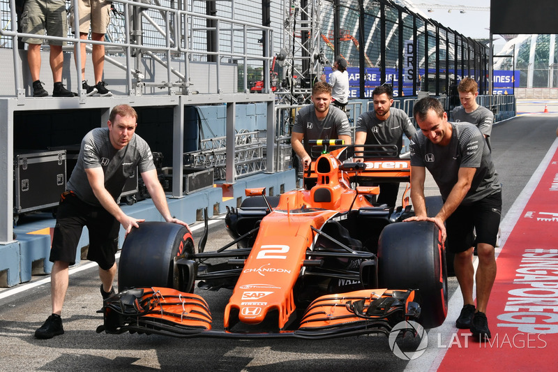 Механики McLaren катят автомобиль MCL32 по пит-лейну
