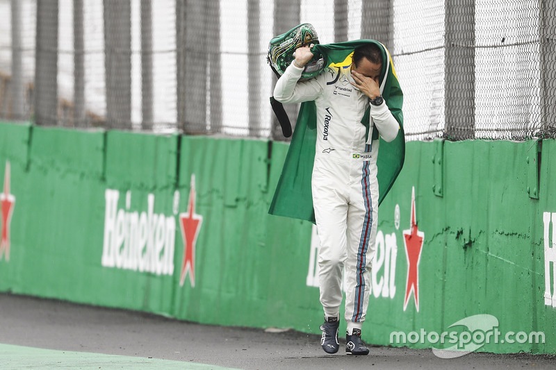 Felipe Massa, Williams, walks back to the garage in tears carrying a Brazilian flag afer crashing