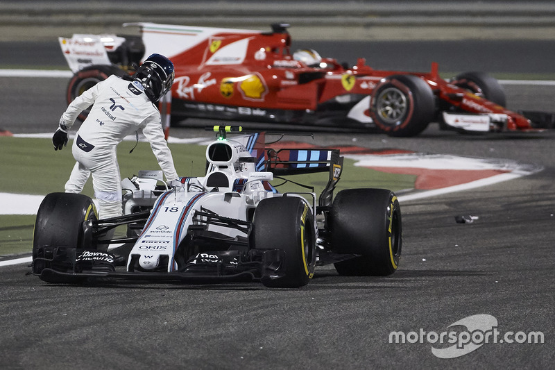 Sebastian Vettel, Ferrari SF70H, passes Lance Stroll, Williams FW40, as he climbs out of his damaged