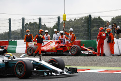 Lewis Hamilton, Mercedes AMG F1 W08, passes the crashed car of Kimi Raikkonen, Ferrari SF70H, as mar