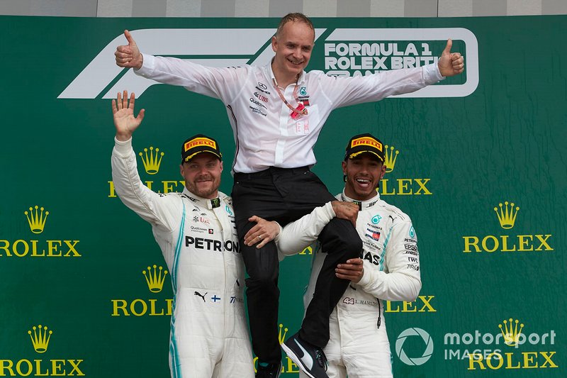 Valtteri Bottas, Mercedes AMG F1, 2nd position, and Lewis Hamilton, Mercedes AMG F1, 1st position, lift their team mate onto their shoulders on the podium