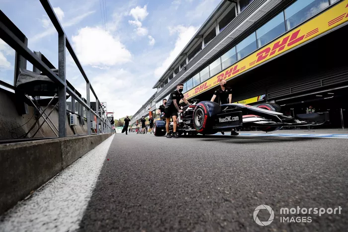 Mecánicos de Haas empujan el VF-20 de Haas en el pit lane