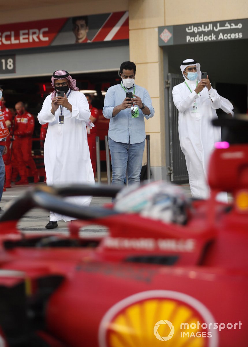 Para tamu VIP memotret Charles Leclerc, Ferrari SF21, di pit lane