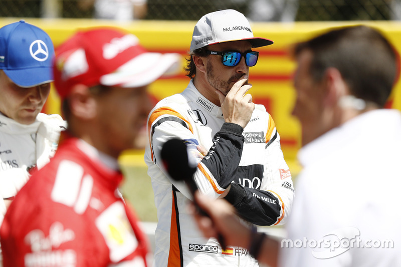 Fernando Alonso, McLaren, looks on as Valtteri Bottas, Mercedes AMG F1, Sebastian Vettel, Ferrari, are interviewed