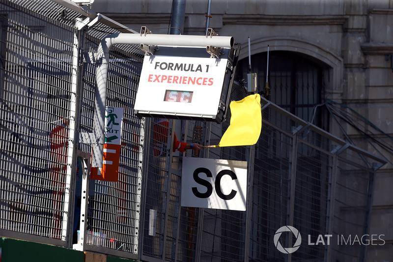 Marshal waves the Yellow Flag and Safety Car board