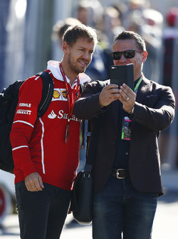 Sebastian Vettel, Ferrari, takes a picture with a fan