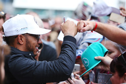 Lewis Hamilton, Mercedes AMG F1, bumps fists with a fan, in between signing autographs
