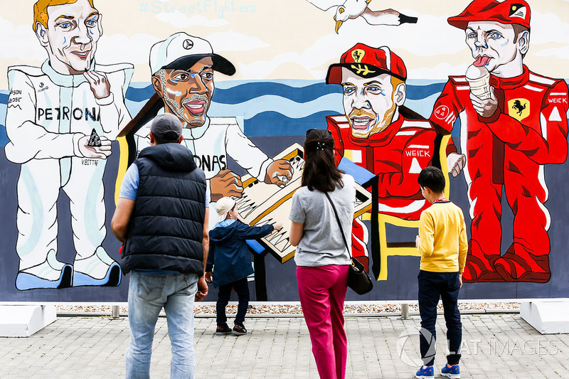 Los fanáticos miran obras de arte que representan a Valtteri Bottas, Mercedes AMG F1, Lewis Hamilton, Mercedes AMG F1, Sebastian Vettel, Ferrari y Kimi Raikkonen, Ferrari, jugando al backgammon