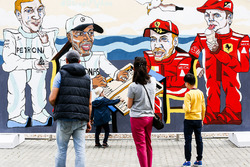 Los fanáticos miran obras de arte que representan a Valtteri Bottas, Mercedes AMG F1, Lewis Hamilton, Mercedes AMG F1, Sebastian Vettel, Ferrari y Kimi Raikkonen, Ferrari, jugando al backgammon