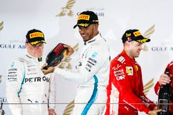 Valtteri Bottas, Mercedes AMG F1, 2nd position, Lewis Hamilton, Mercedes AMG F1, 3rd position, and Sebastian Vettel, Ferrari, 1st position, spray Waard, a non-alcoholic Champagne Rose Water substitute, on the podium