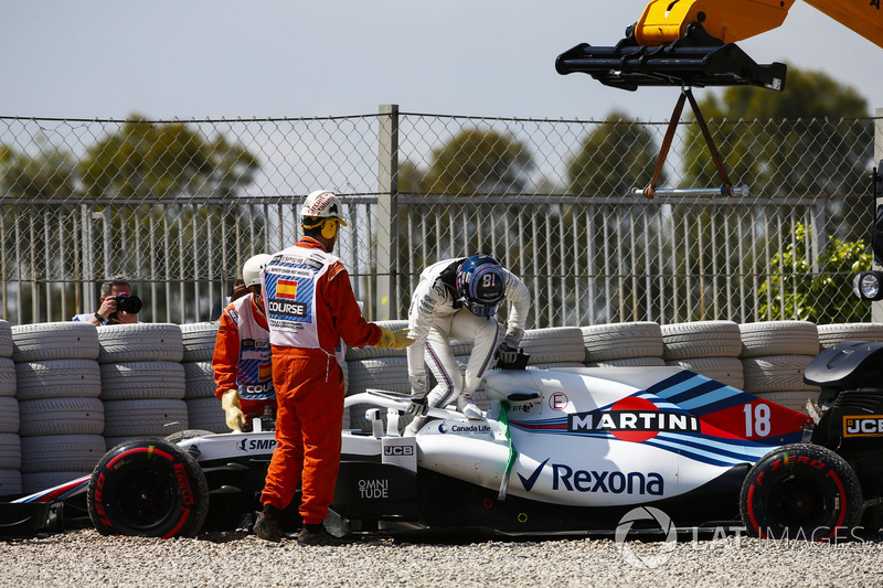 Lance Stroll, Williams FW41, climbs out of his car and is assisted by marshals after spinning into the gravel