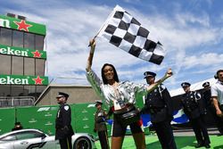 Winnie Harlow, waves a chequered flag