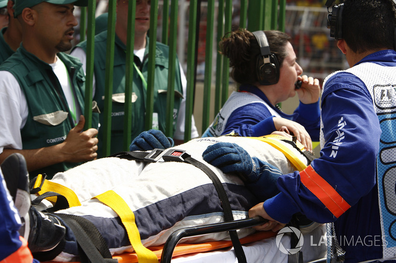 Un mecánico de Williams en camilla después de ser golpeado por Kazuki Nakajima, Williams FW29 durante una parada en boxes