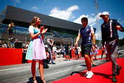 Grid Girls in national costume flank the drivers parade as Lance Stroll, Williams Racing, and Esteban Ocon, Force India, pass