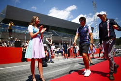 Grid Girls in national costume flank the drivers parade as Lance Stroll, Williams Racing, and Esteban Ocon, Force India, pass