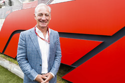 Greg Maffei, Chief Executive Officer, Liberty Media, in front of an F1 logo